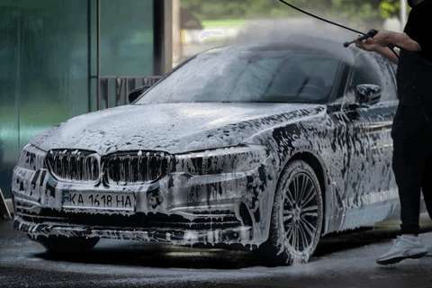 Hand-detailed car covered in foam during wash